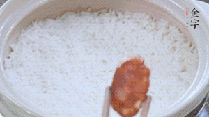 煮開(kāi)后轉(zhuǎn)小火，當(dāng)米飯出現(xiàn)小孔時(shí)，鋪上金字麻辣香腸。